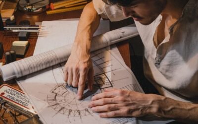 Architect sketching architectural plans with tools in a creative workspace setting.