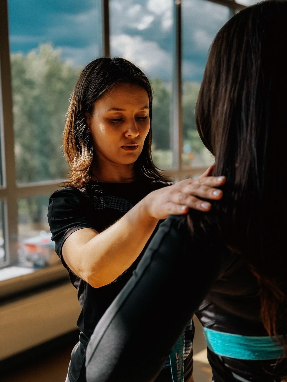 Focused personal trainer assists a client in a gym with guidance and support, fostering a fitness journey.