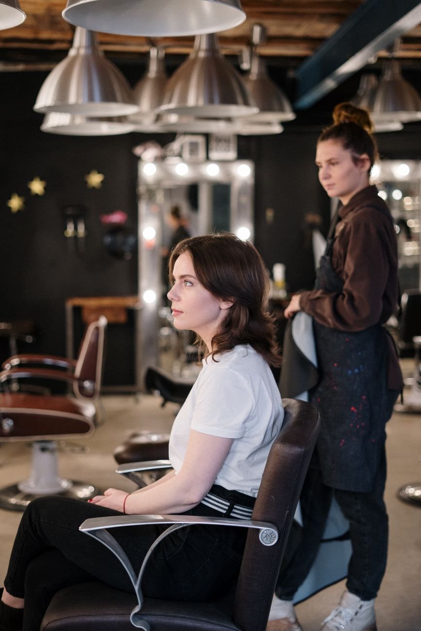 Woman receiving a haircut in a modern salon, stylist in focus.