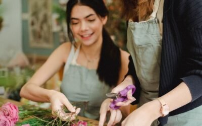 Young smiling multiracial female floral designers creating flower compositions while working in shop together