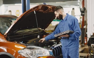 Skilled mechanic working on car engine diagnostics in a modern garage.