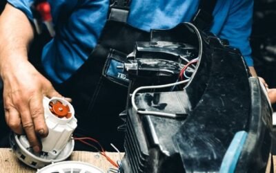 Experienced technician focused on repairing an electrical machine in a workshop setting.