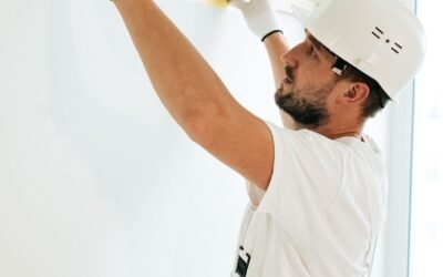 A construction worker using a spirit level to ensure accuracy on a wall installation.